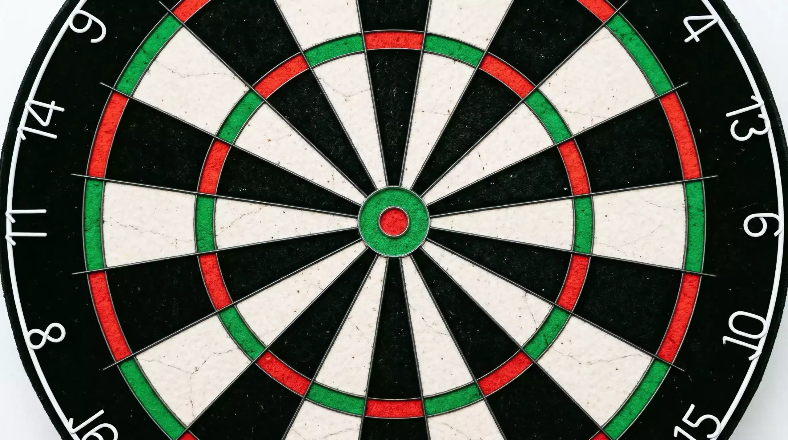 Notizbuch mit Budget-Planung und Stift neben Dartpfeilen auf einem Schreibtisch – Bankroll Management für Darts-Wetten