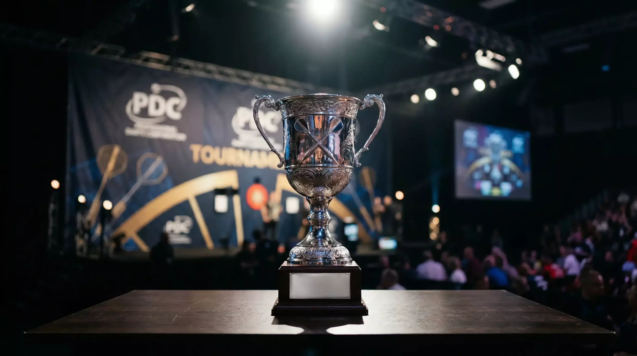 Darts-Pokal auf einer Bühne mit PDC-Turnier-Banner im Hintergrund – Langzeitwetten auf Turniersieger