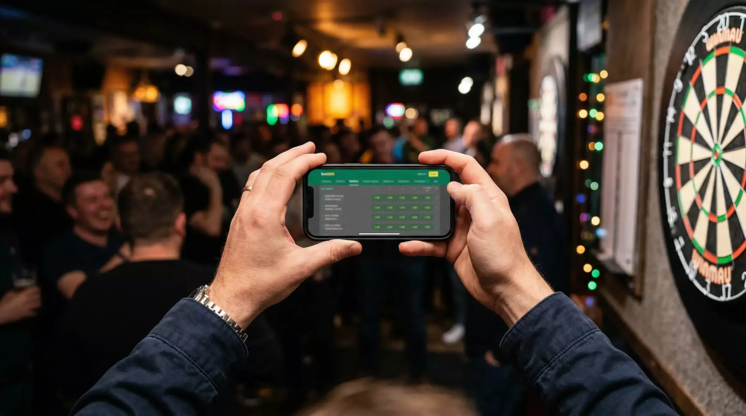 Darts Wettanbieter Vergleich — Smartphone mit Wettquoten vor einem Darts-Event