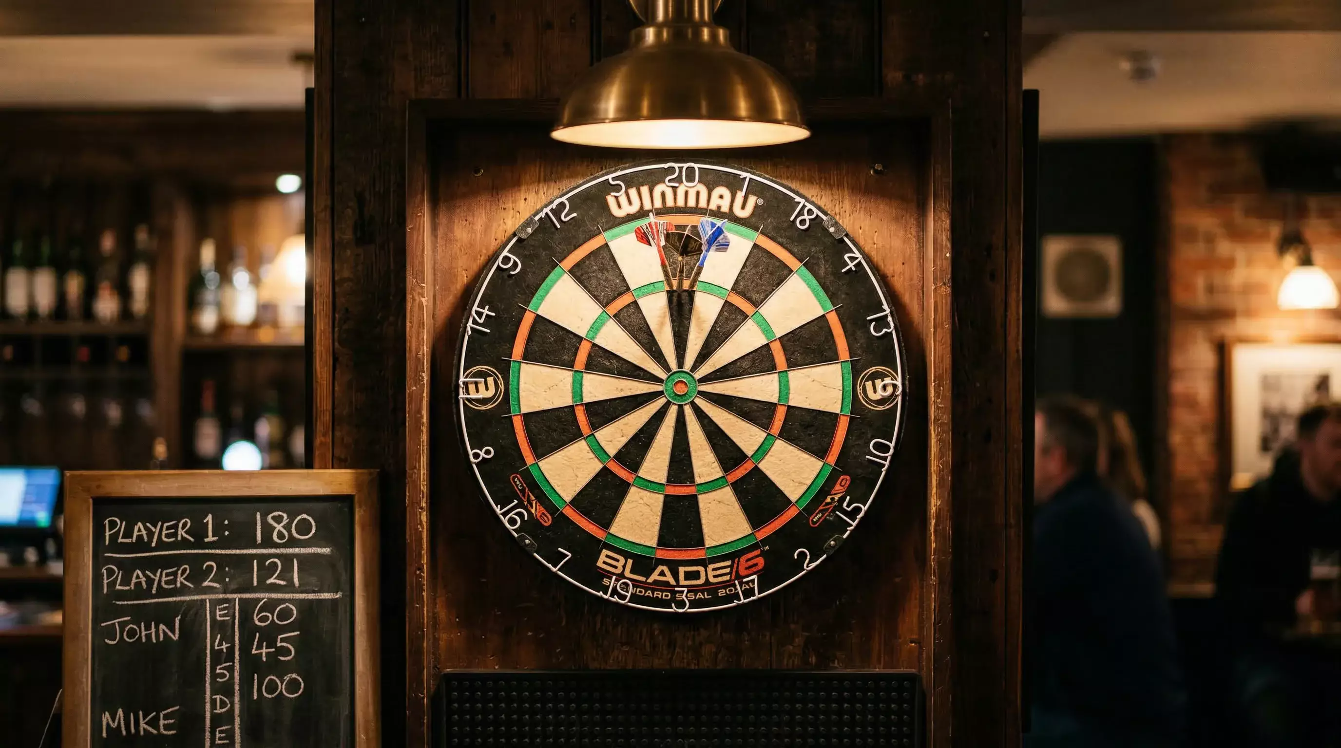 Гњbersicht der Darts-Wettarten mit Siegwette und Handicap auf einer Anzeigetafel im Pub